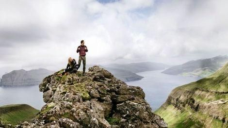 View of two people on top of a mountain in the Faroe Islands